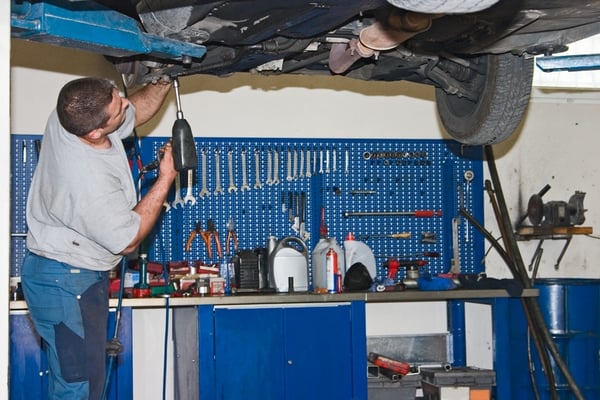 Discount Auto Center mechanic working beneath a vehicle